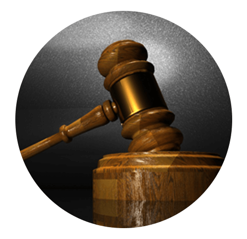 A gavel leaning on a round wooden sound block representing lawsuits.